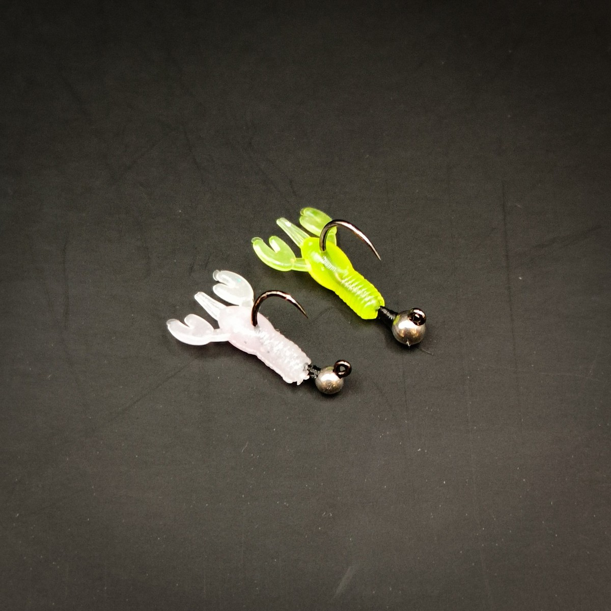 Nano Pincher rigged on micro jig heads Pearl White and Chartreuse Nano Pincher lures rigged on micro jig heads against a dark background